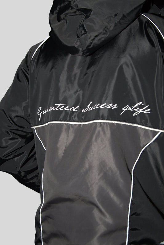 A black windbreaker with white text and detailing. The text reads ' Guaranteed Success Life '.